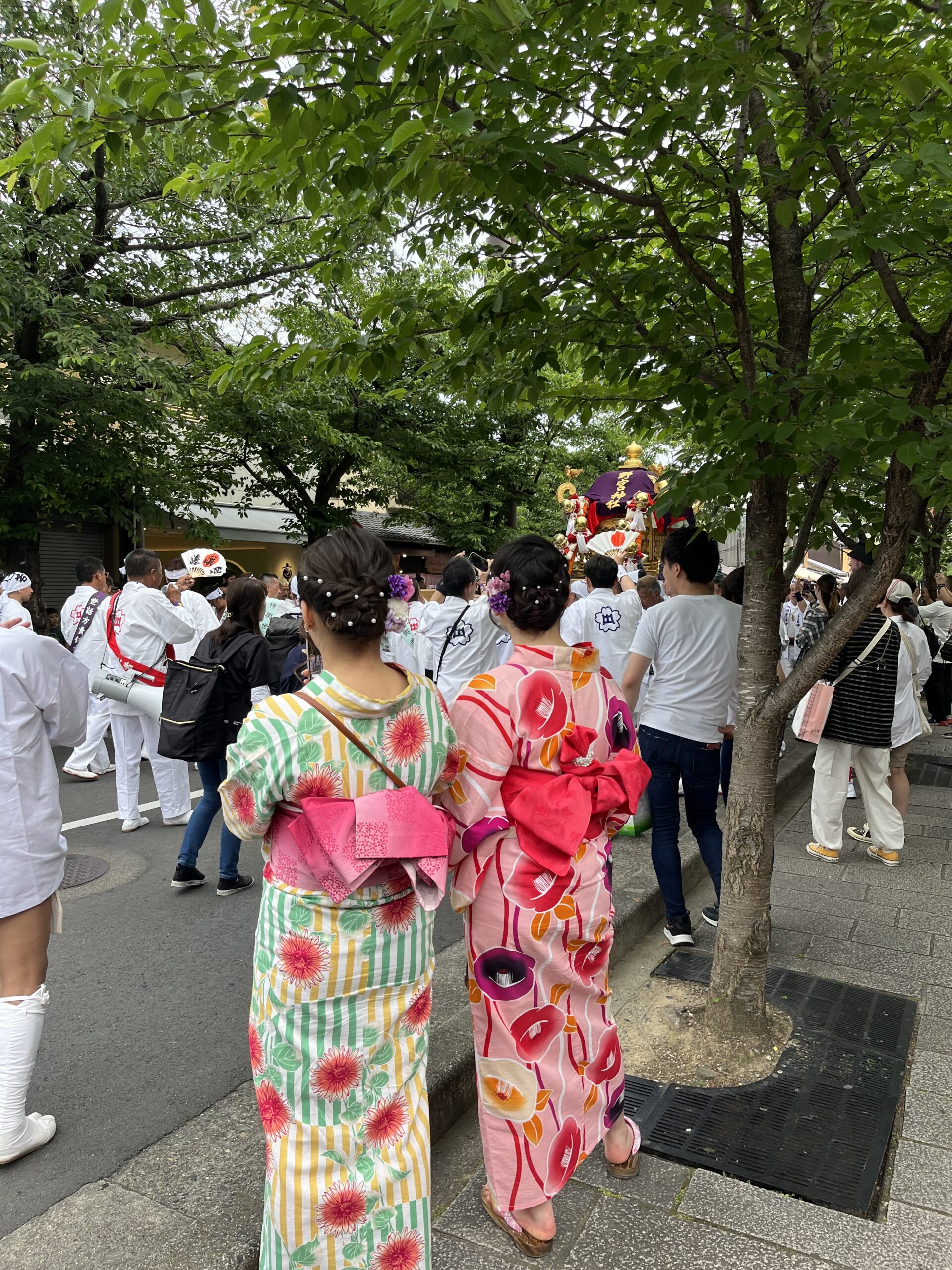 Two girls watching a parade wearing bright summer yukata's.