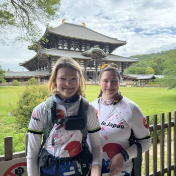 Two people in cycling jersey's stand in front of a famous Buddhist temple, Todaiji in Nara Japan.