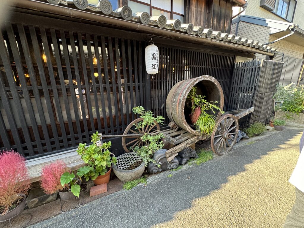 Japanese street with plants and barrel and old fashion wagon.