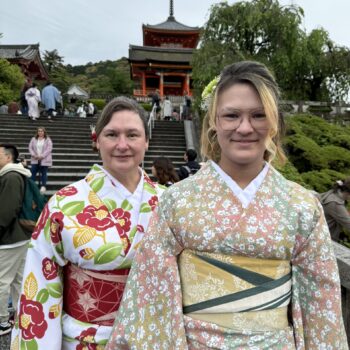 Two woman pose in beautiful colorful flower Kimonos.