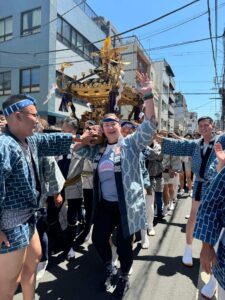 Matsuri celebration in Japan, visitor carry's golden float with other team members. Get immersed in local festivals.
