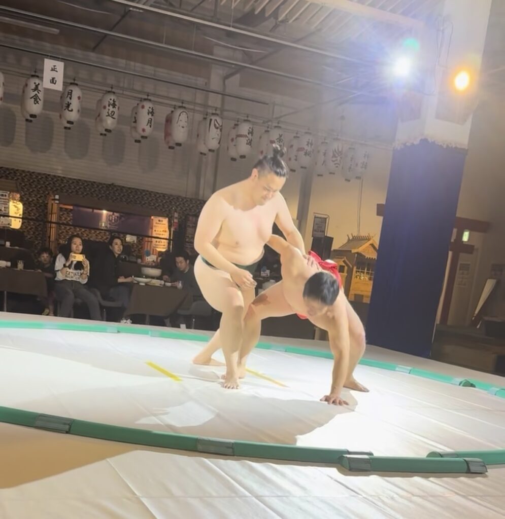 Two men Sumo Wrestling at tourist Sumo restaurant in Rinku Town, Osaka, Japan.